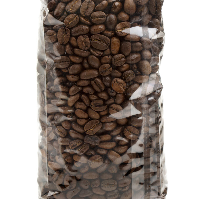 clear plastic bag of coffee beans isolated on white background