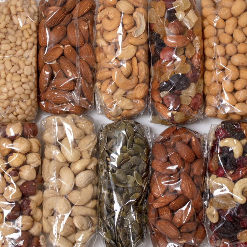 Collection of different nuts in transparent plastic packages.